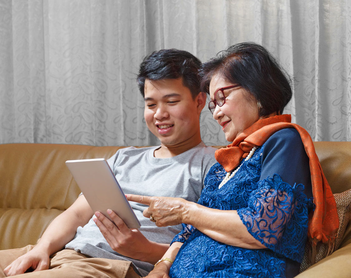 Adult son and senior mom sitting on couch