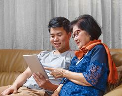 Adult son and senior mom sitting on couch