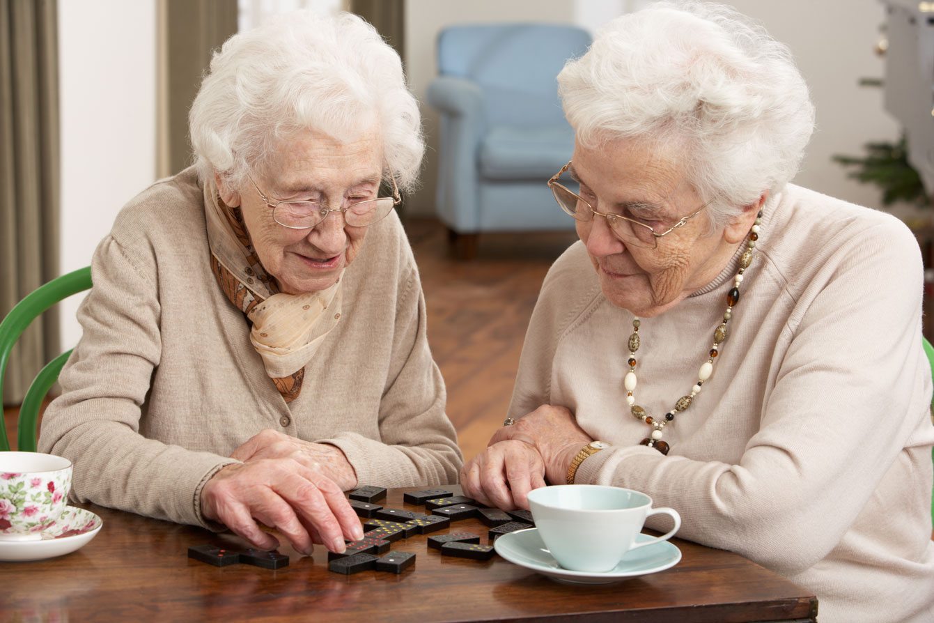 Two senior women playing dominos