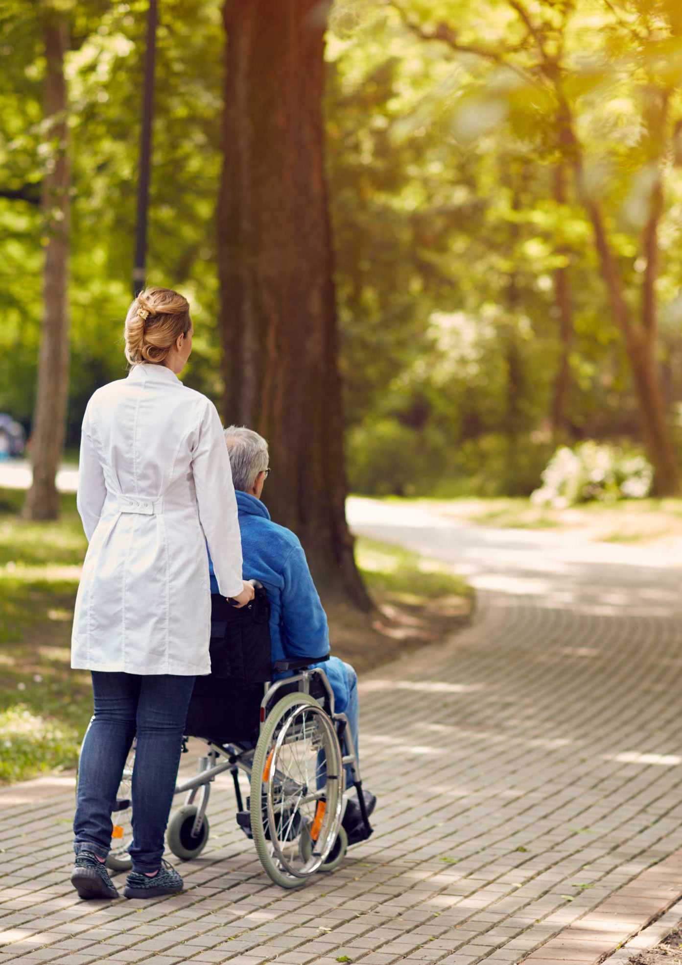 Carer going for a walk with a senior in a wheelchair