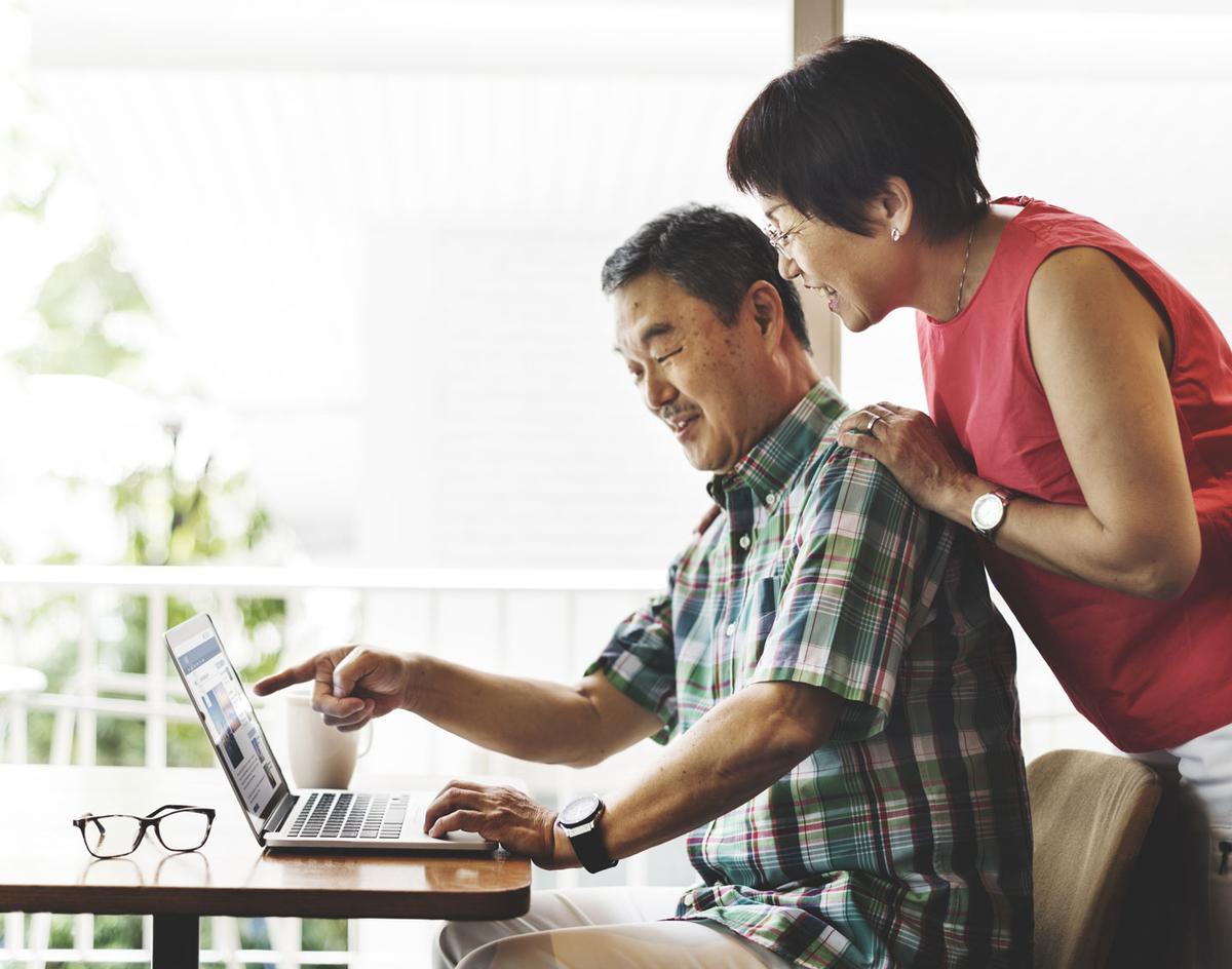 Senior man and woman looking at a computer