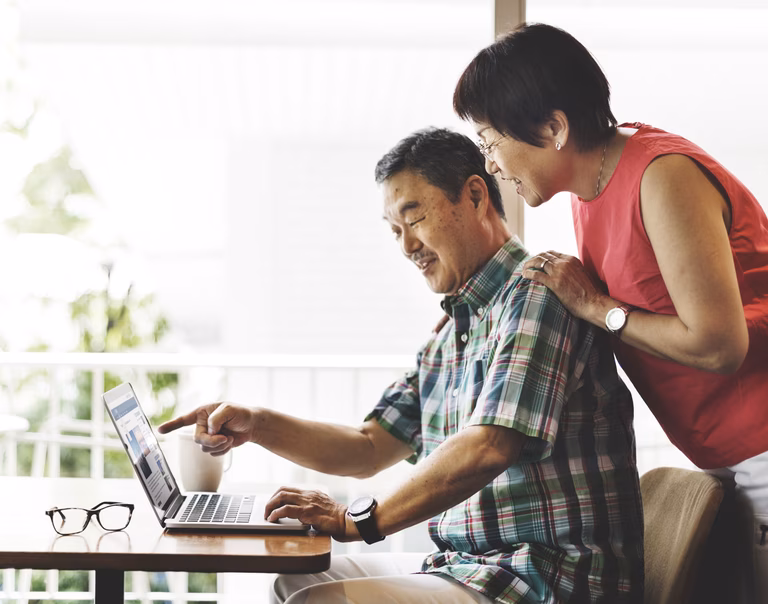 Senior man and woman looking at a computer
