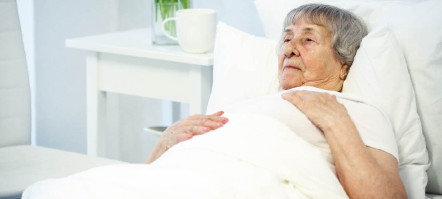 Image of an older woman resting in a hospital bed.