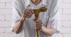Senior mans hands holding a walking cane