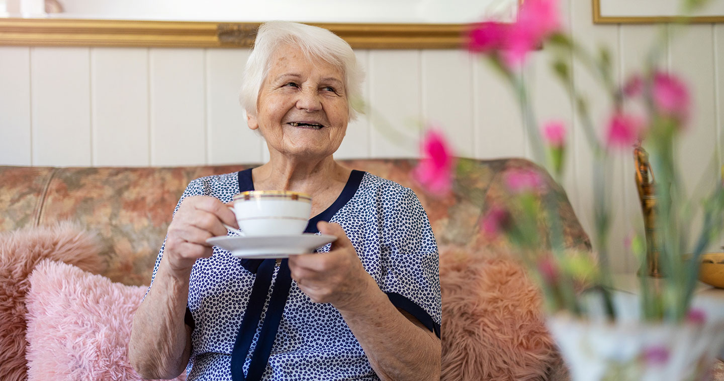 Older woman smiling with cup of tea