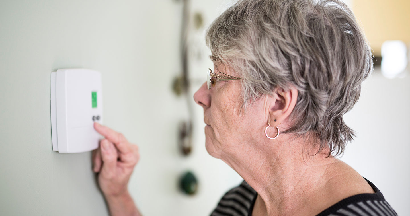 Older woman working air-conditioning panel