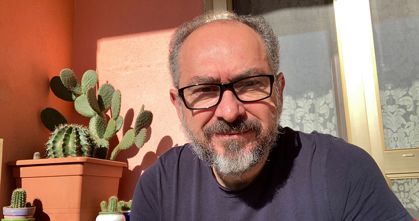 Older man with glasses and beard looking to camera