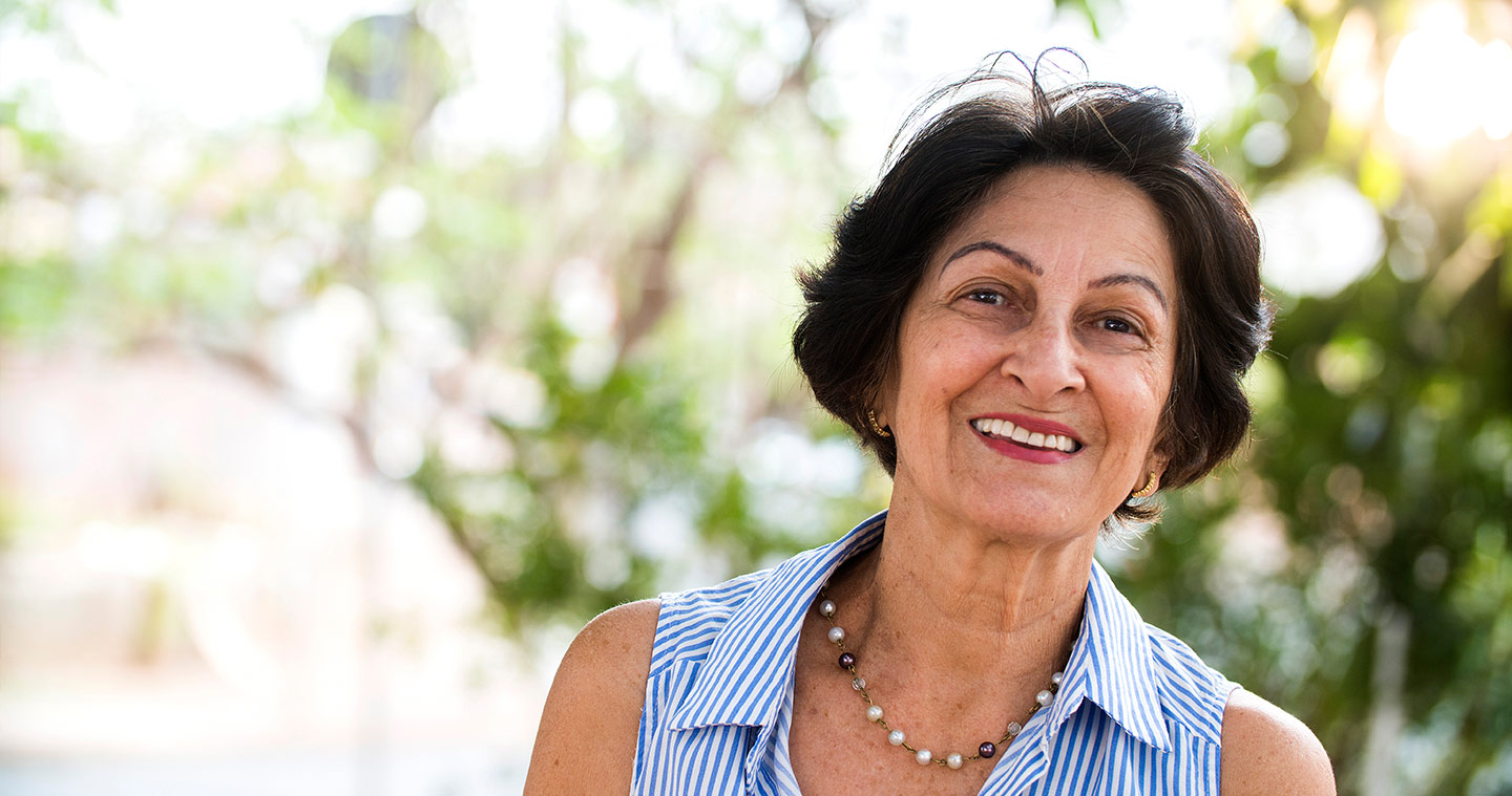 Image of an older woman with a blue and white stripe shirt