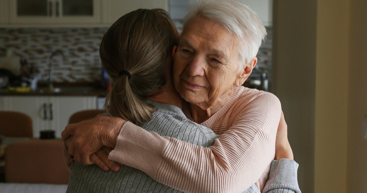 Image of an older woman and a younger woman embracing