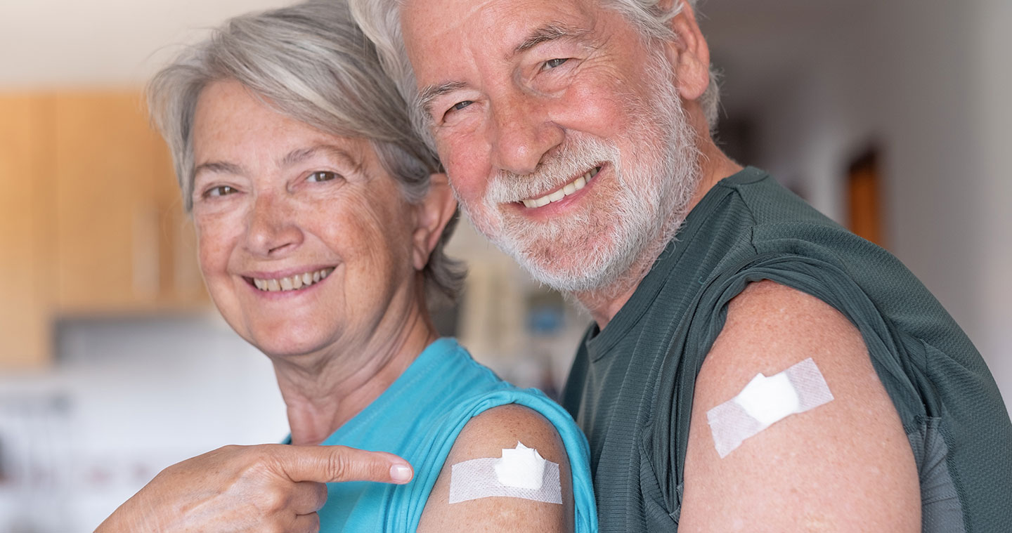 older couple with band aids on arms from injection