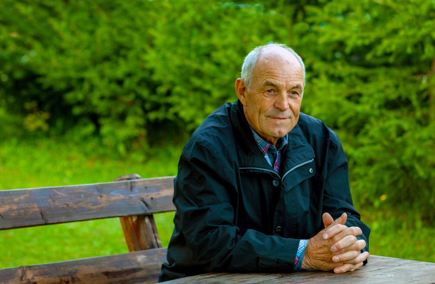 Senior man sitting at a bench in the park 
