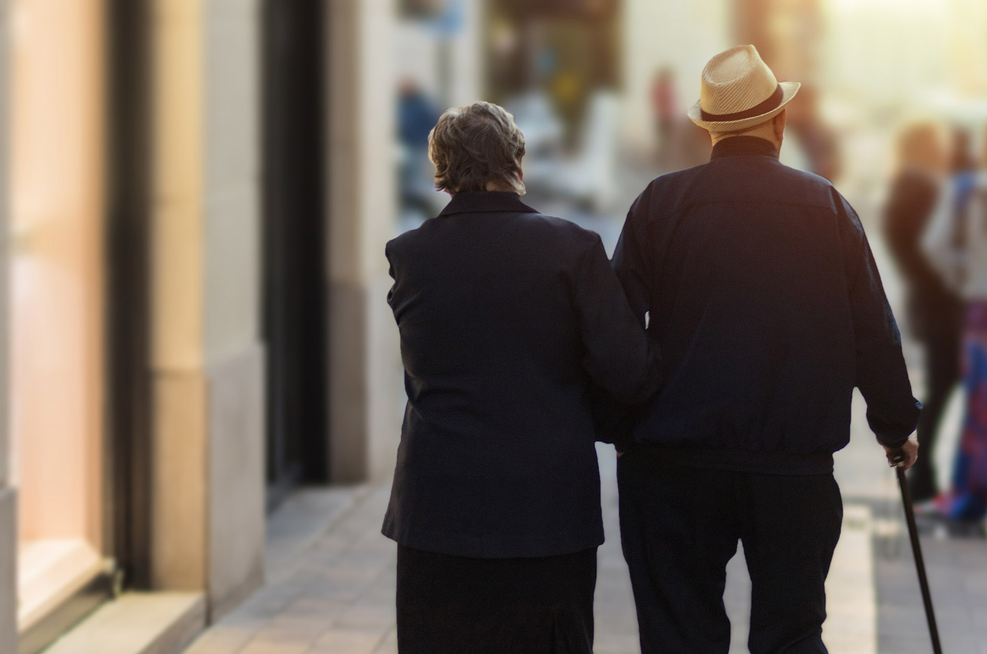 Older couple walking down the street in silhouette