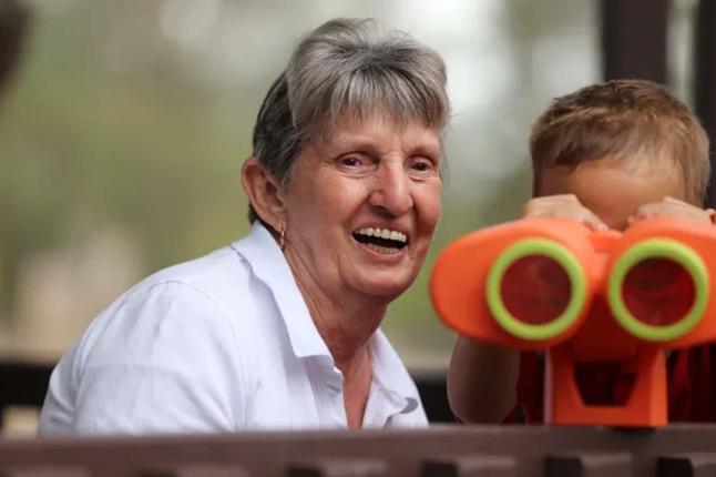Photo of a woman with a small child and toy binoculars