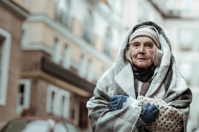 Photo of an older woman wrapped in blankets and woollens