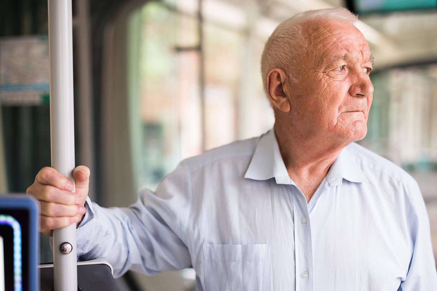 Photo of a man in a pale blue shirt on public transport