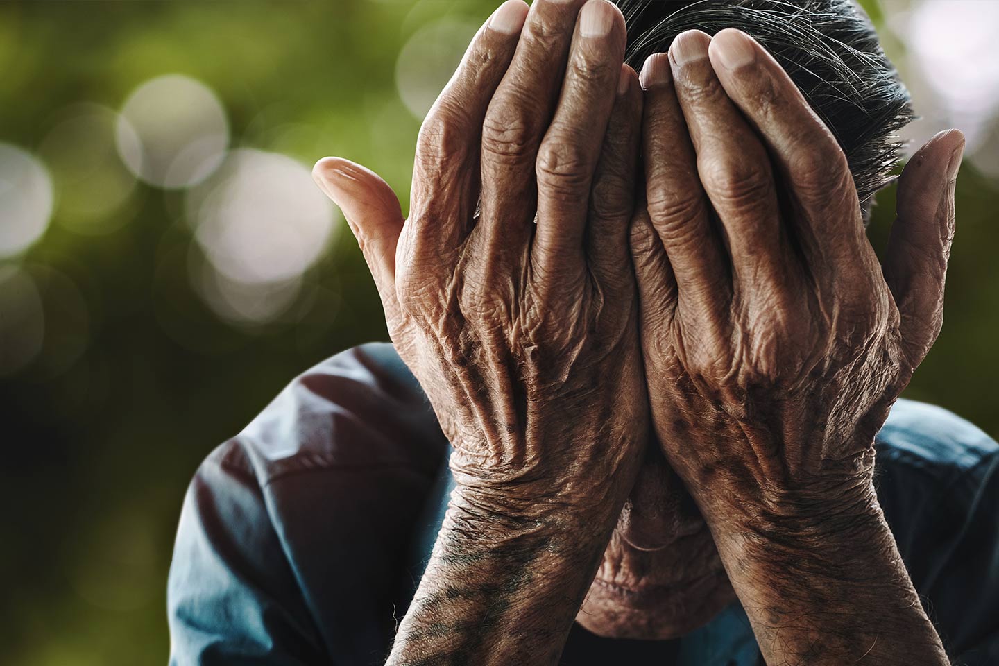 Photo of hands covering a person's face