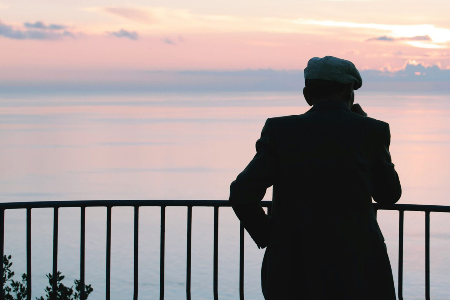 Photo of a man in a cap silhouetted against a sunset