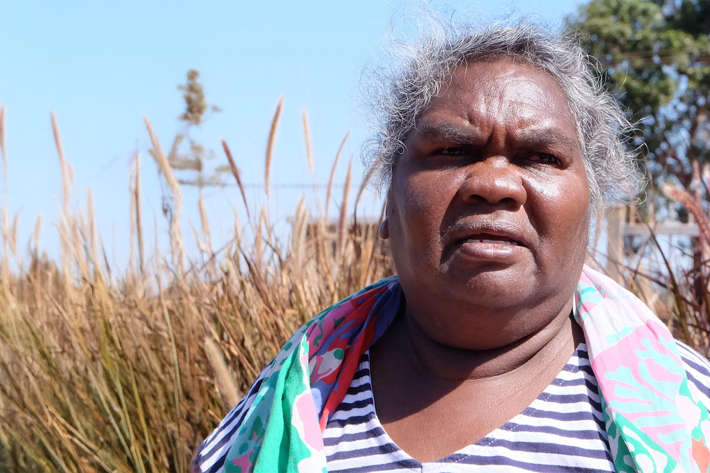 Photo of a woman in a striped top outdoors on a sunny day