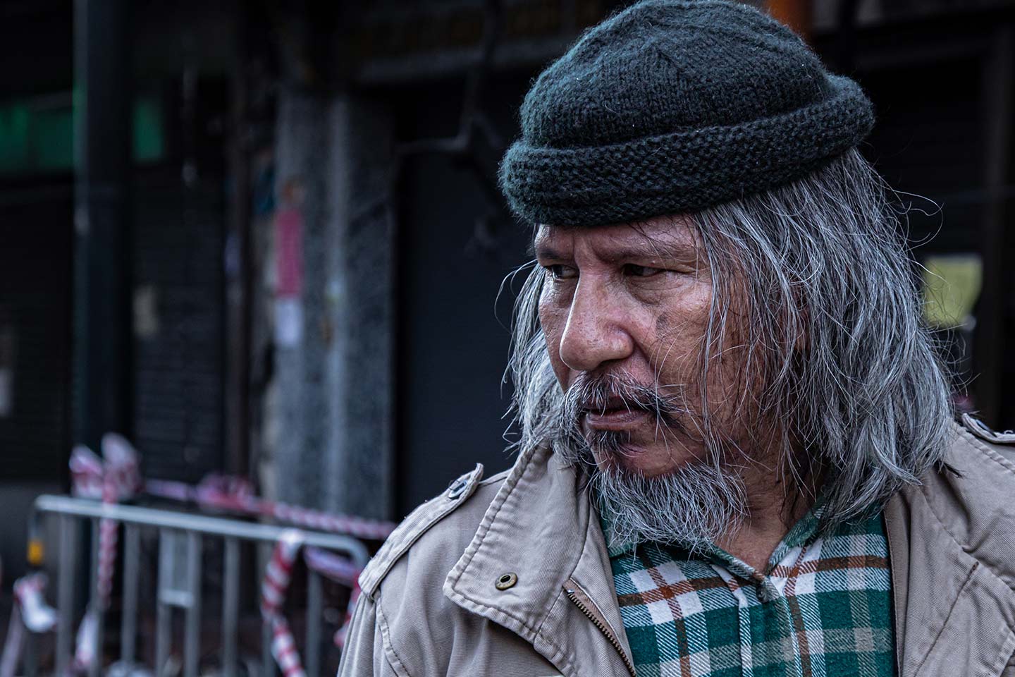 Photo of man wearing a woollen cap and plaid shirt