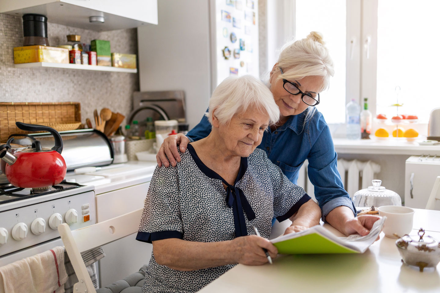 Senior woman with adult daughter going over paperwork