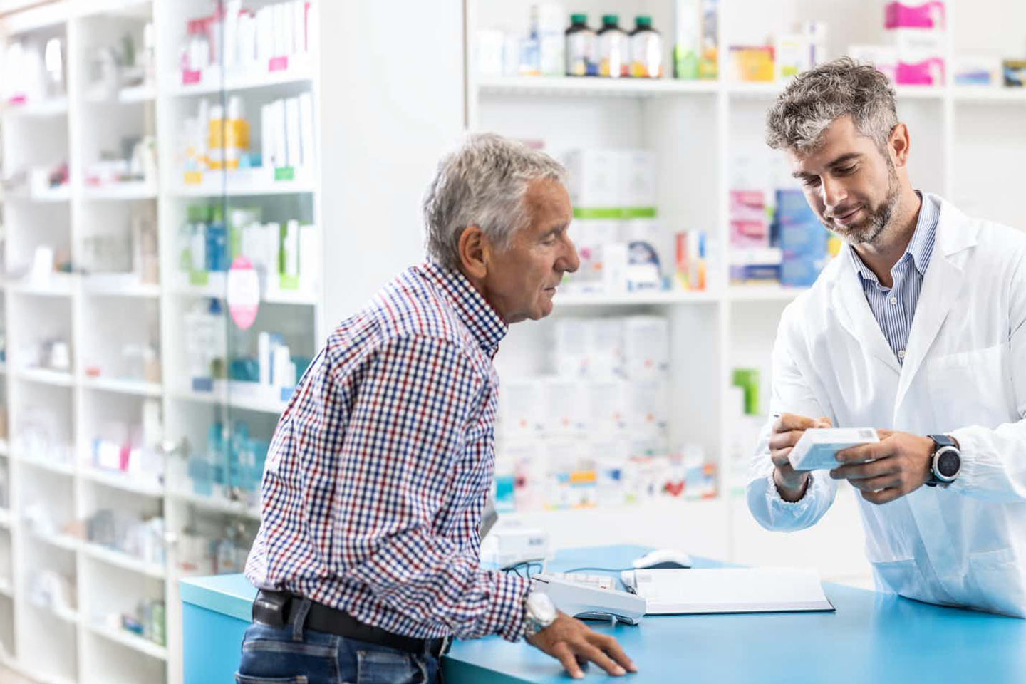 Photo of a pharmacist writing on a customer's pill box