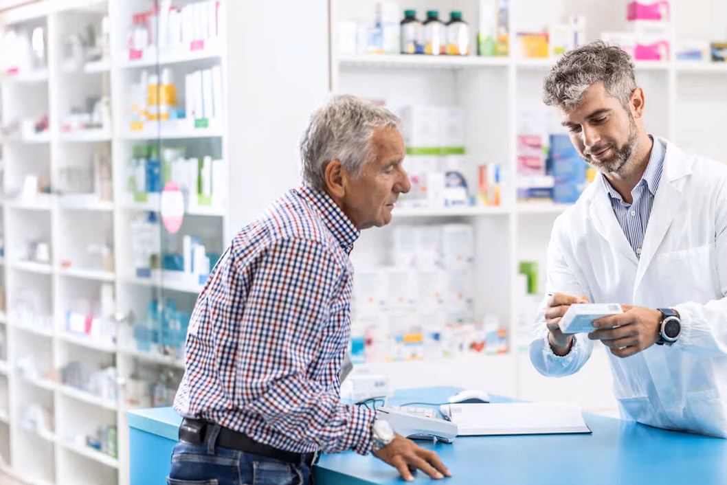 Photo of a pharmacist writing on a customer's pill box