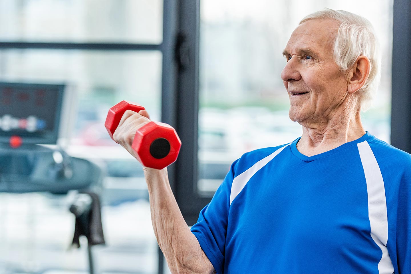 Photo of man in a gym holding a hand weight