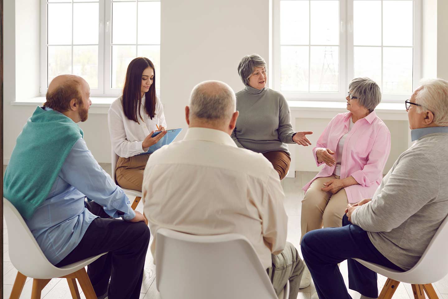 Group of people sitting in a circle in a sunlit room