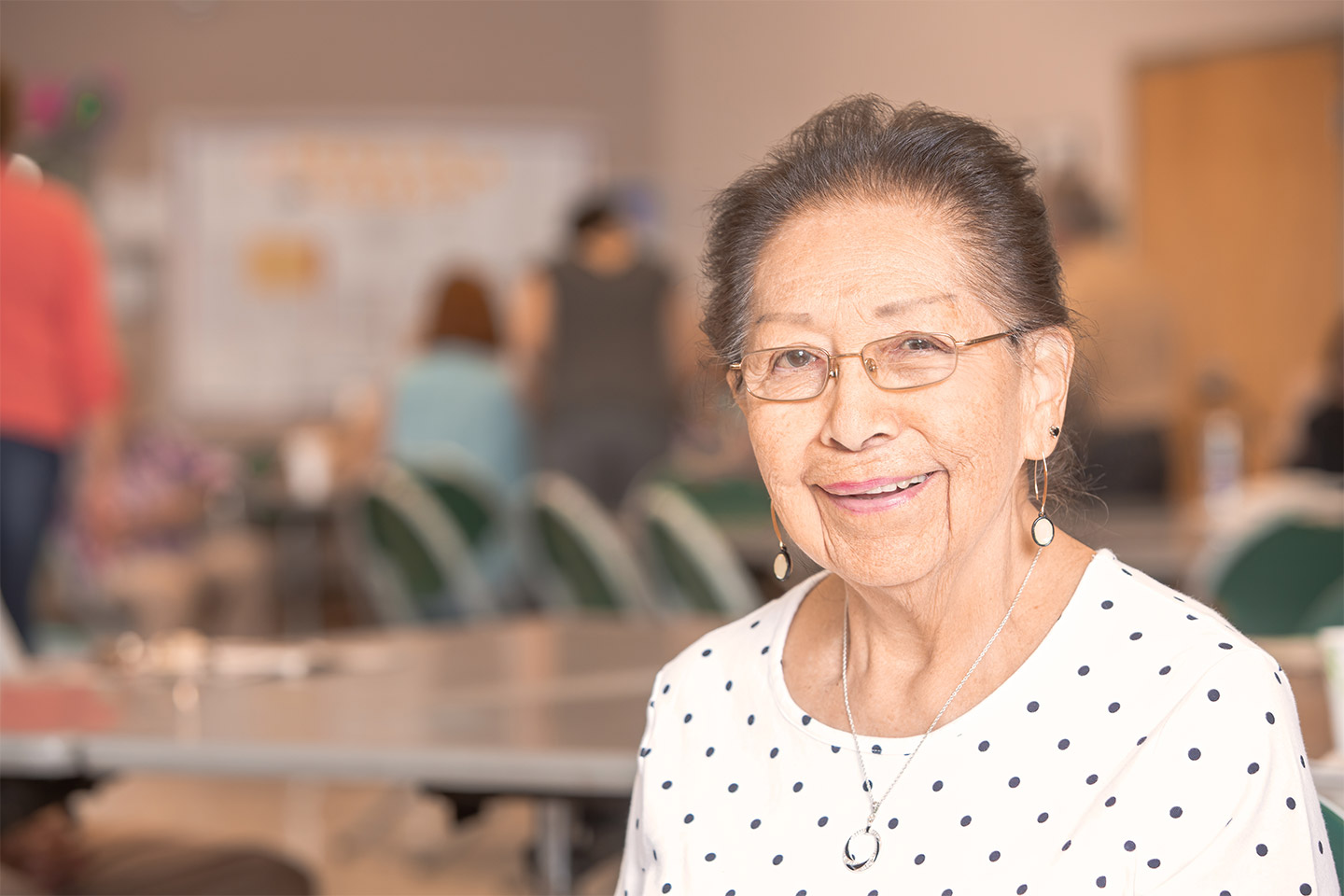 Photo of a smiling lady wearing a polka dot blouse