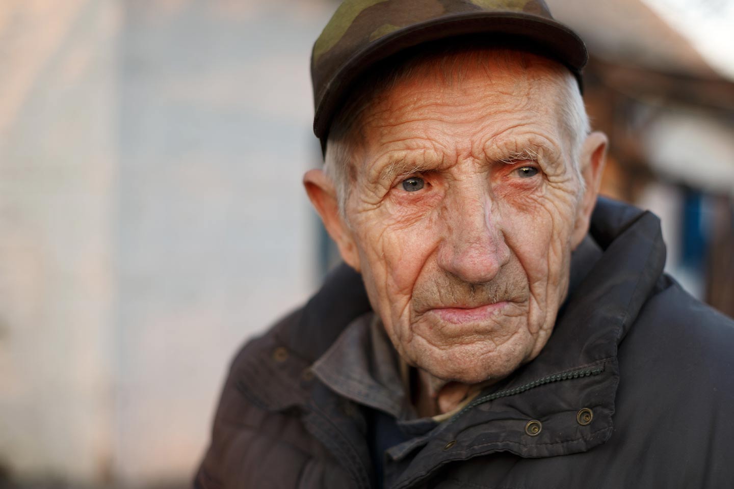 Photo of a man wearing camo cap and charcoal jacket