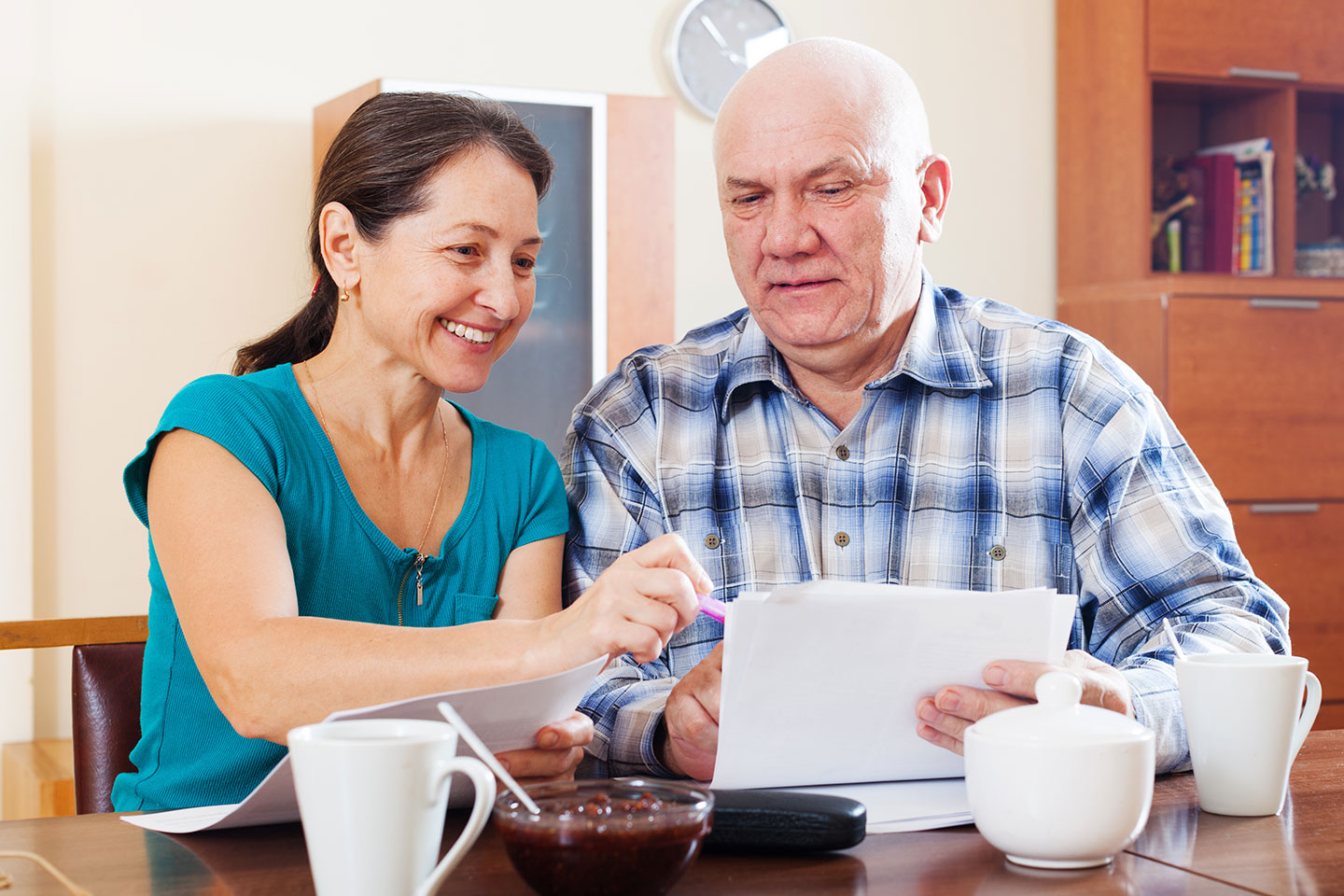 Image of a father and daughter discussing paperwork at the kitchen table