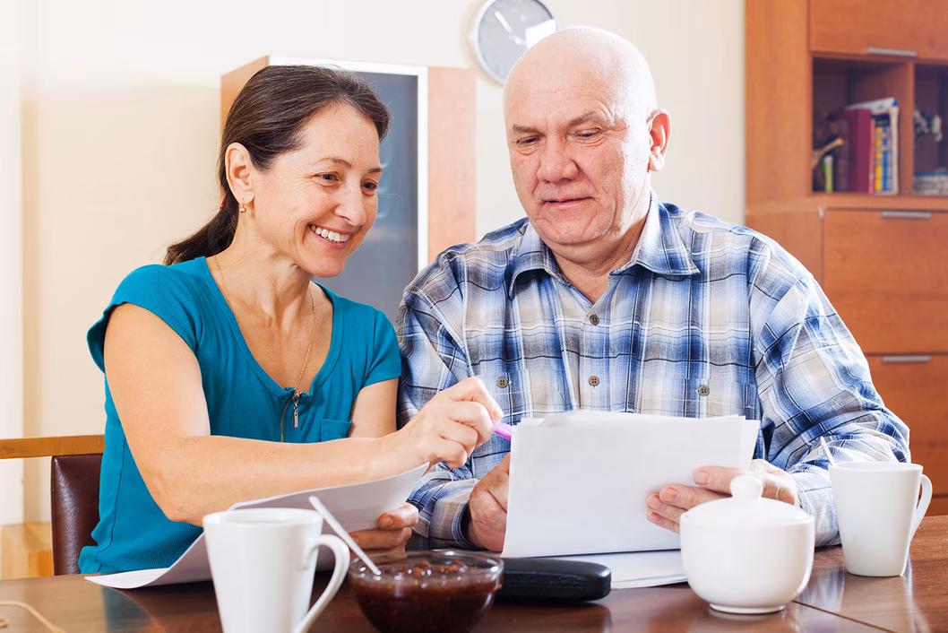 Image of a father and daughter discussing paperwork at the kitchen table