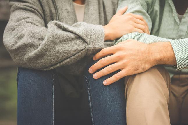 Image of two people holding each other on the knee and arm