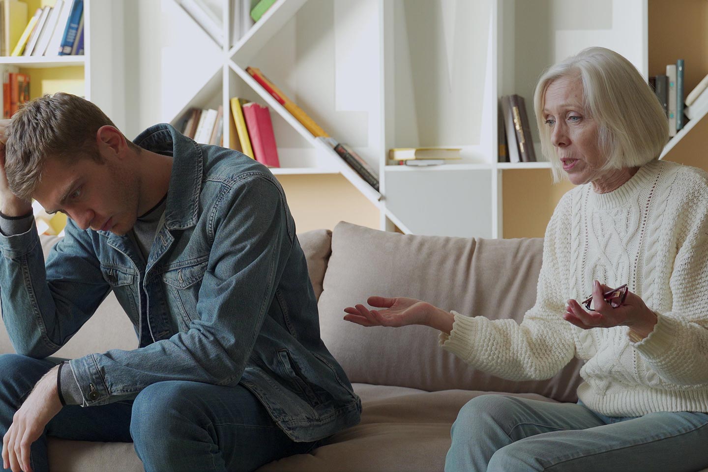 Photo of woman and young manvwearing double denim on a couch