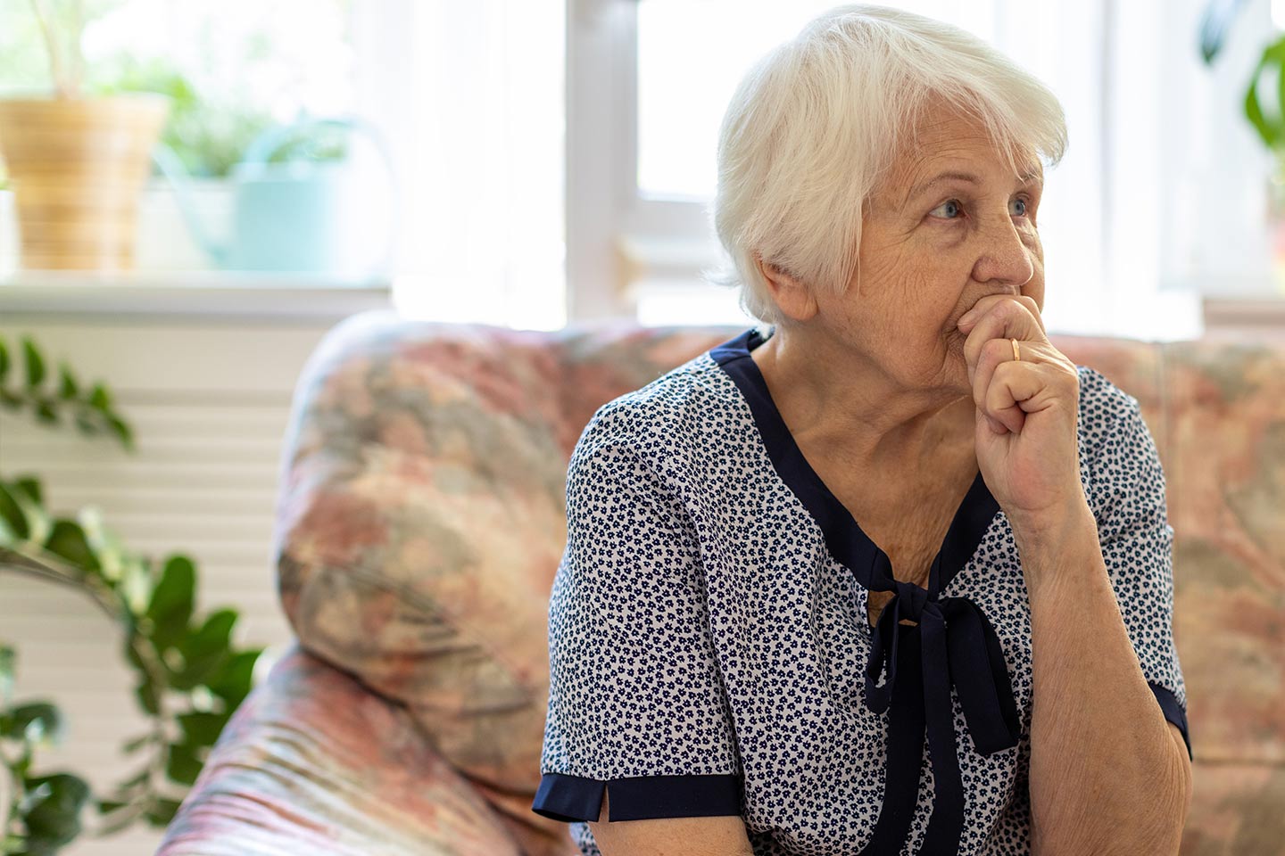 Photo of a woman seated on a floral couch