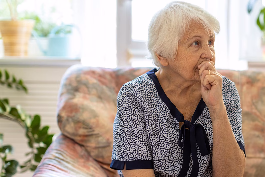 Photo of a woman seated on a floral couch