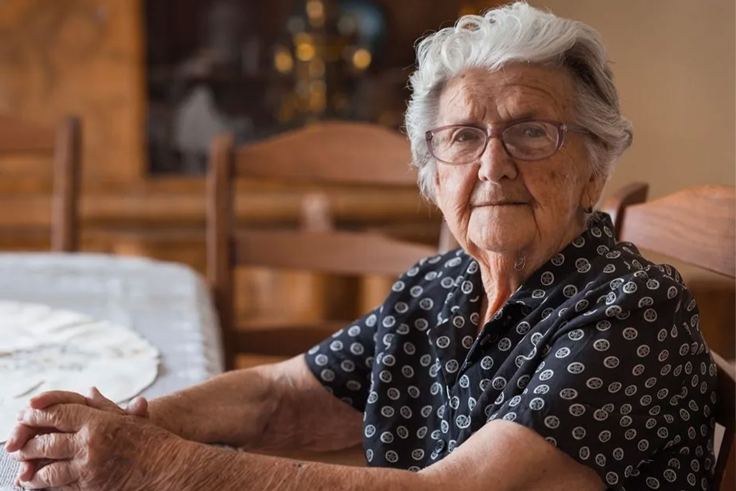 Photo of a woman seated at a lace covered table
