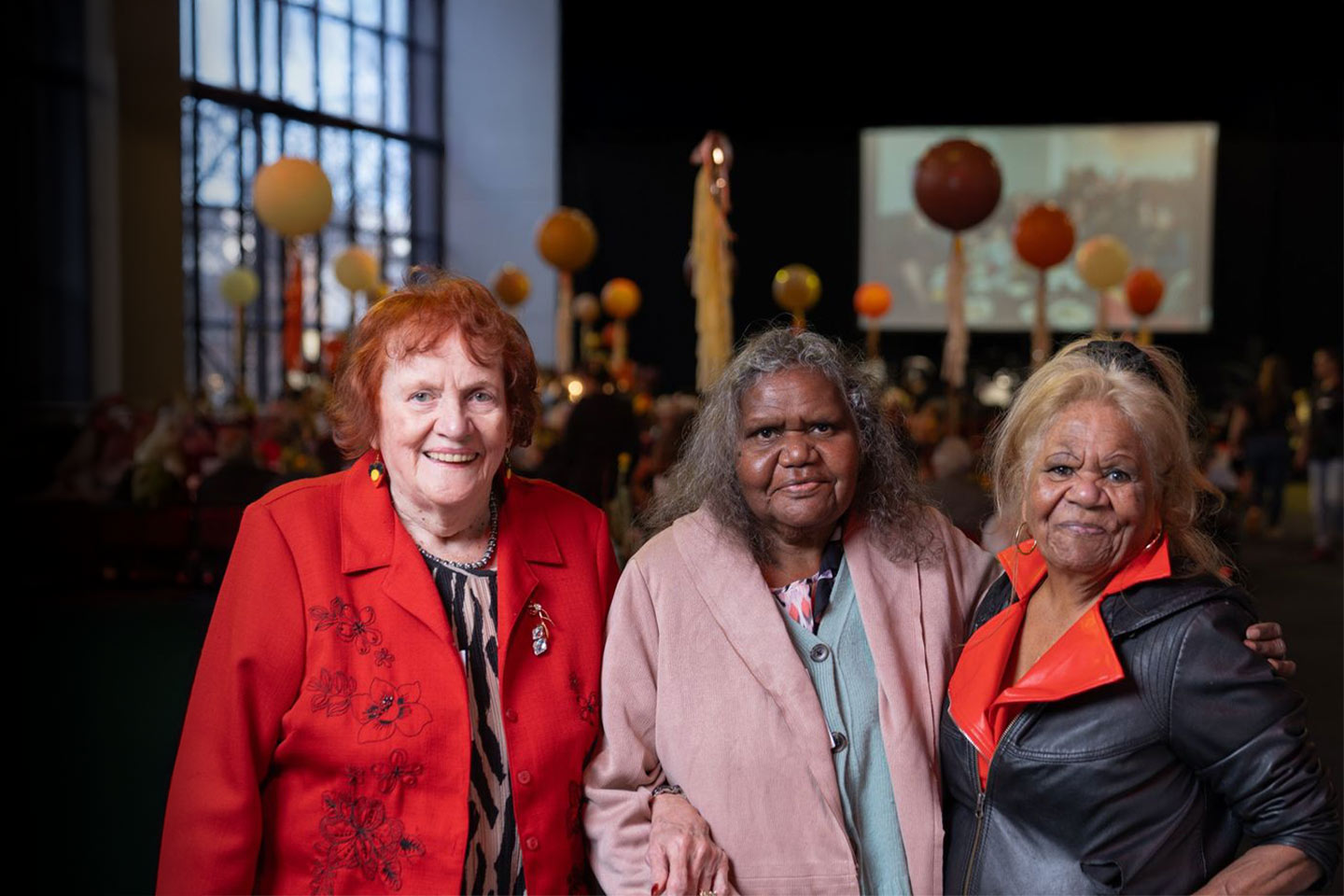 Photo of three women standing together and smiling