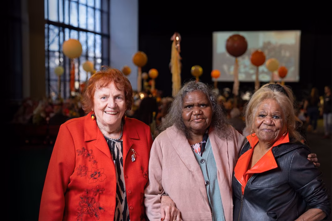 Photo of three women standing together and smiling