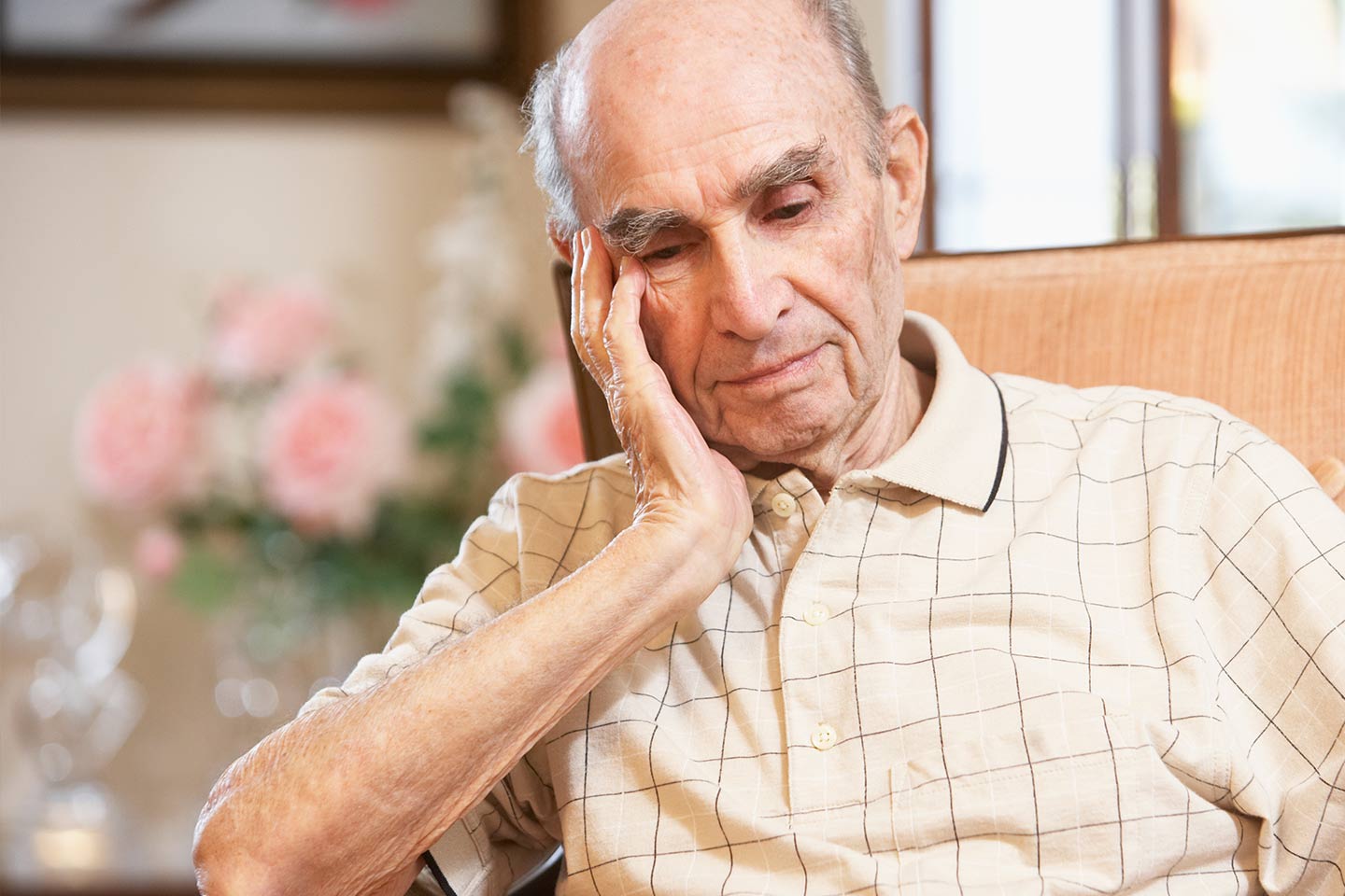 Photo of man in a tan chair resting his head on his hand
