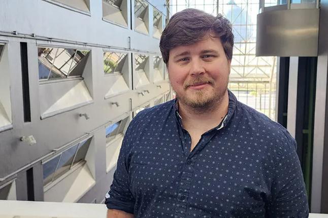 Photo of a bearded man wearing a blue shirt