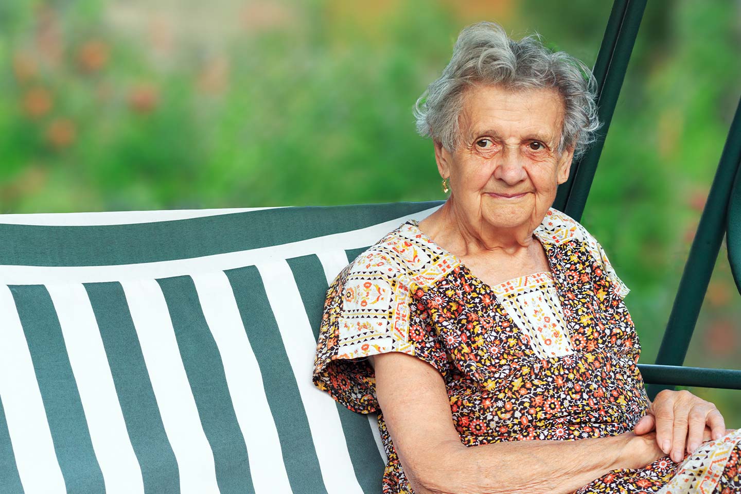 Image of an older woman sitting on a swinging chair