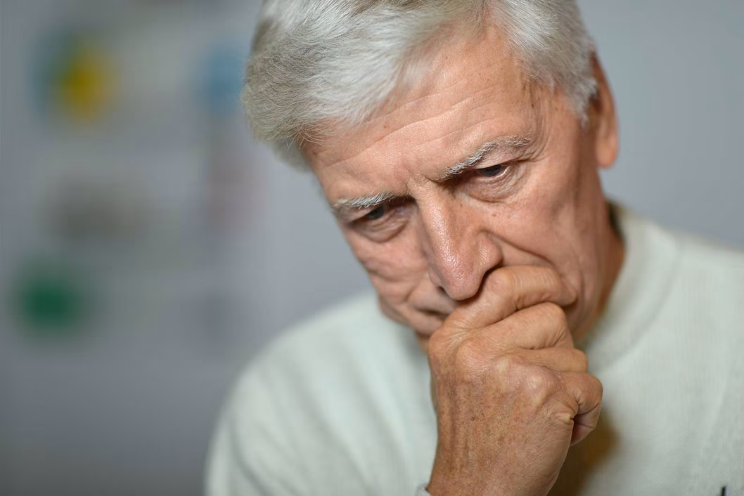 Photo of man looking concerned with chin in hand