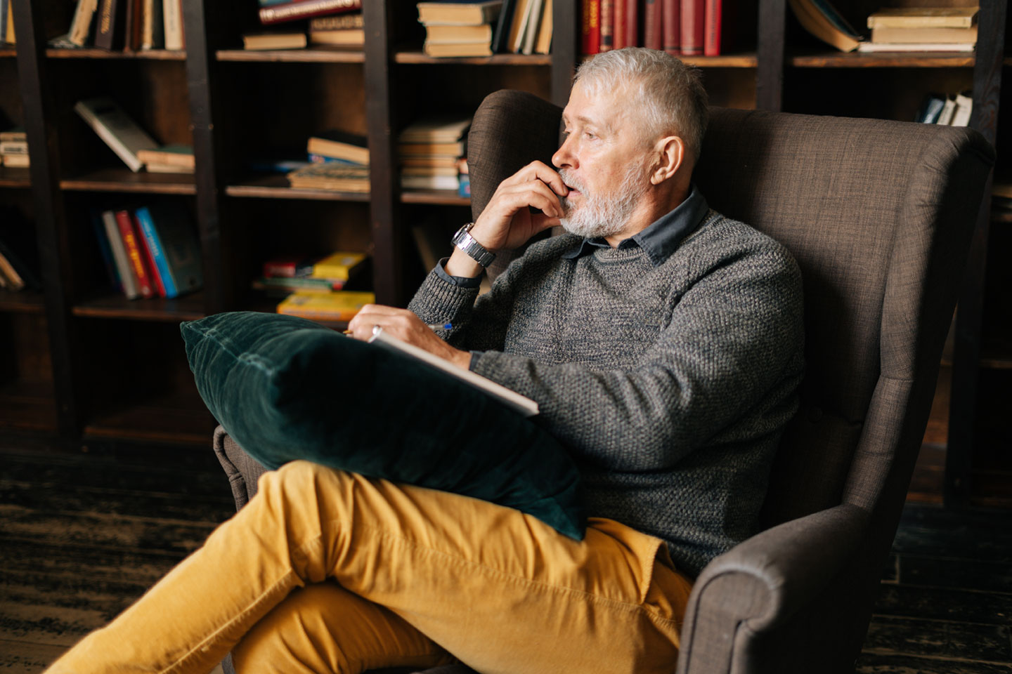 older man sitting down looking away and thinking