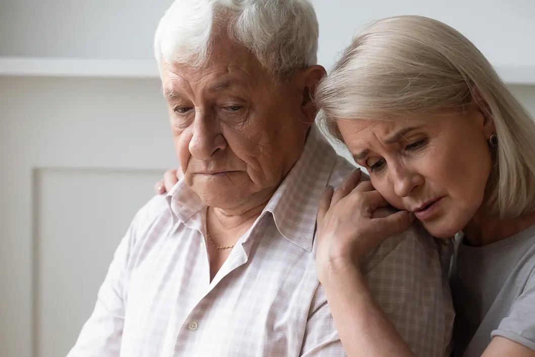 Photo of sad-looking woman comforting a man
