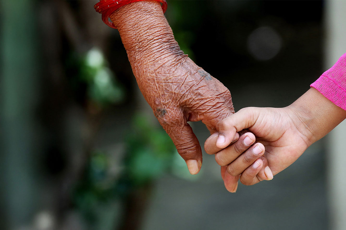 Photo of a younger hand holding an older hand
