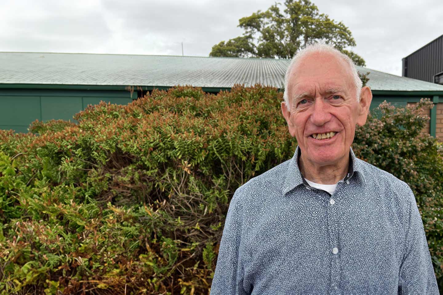 Photo of man in a garden with a green shed