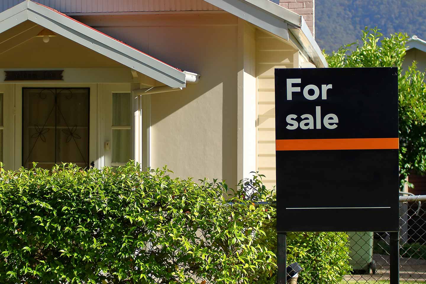 Photo of a For Sale sign in front of a house