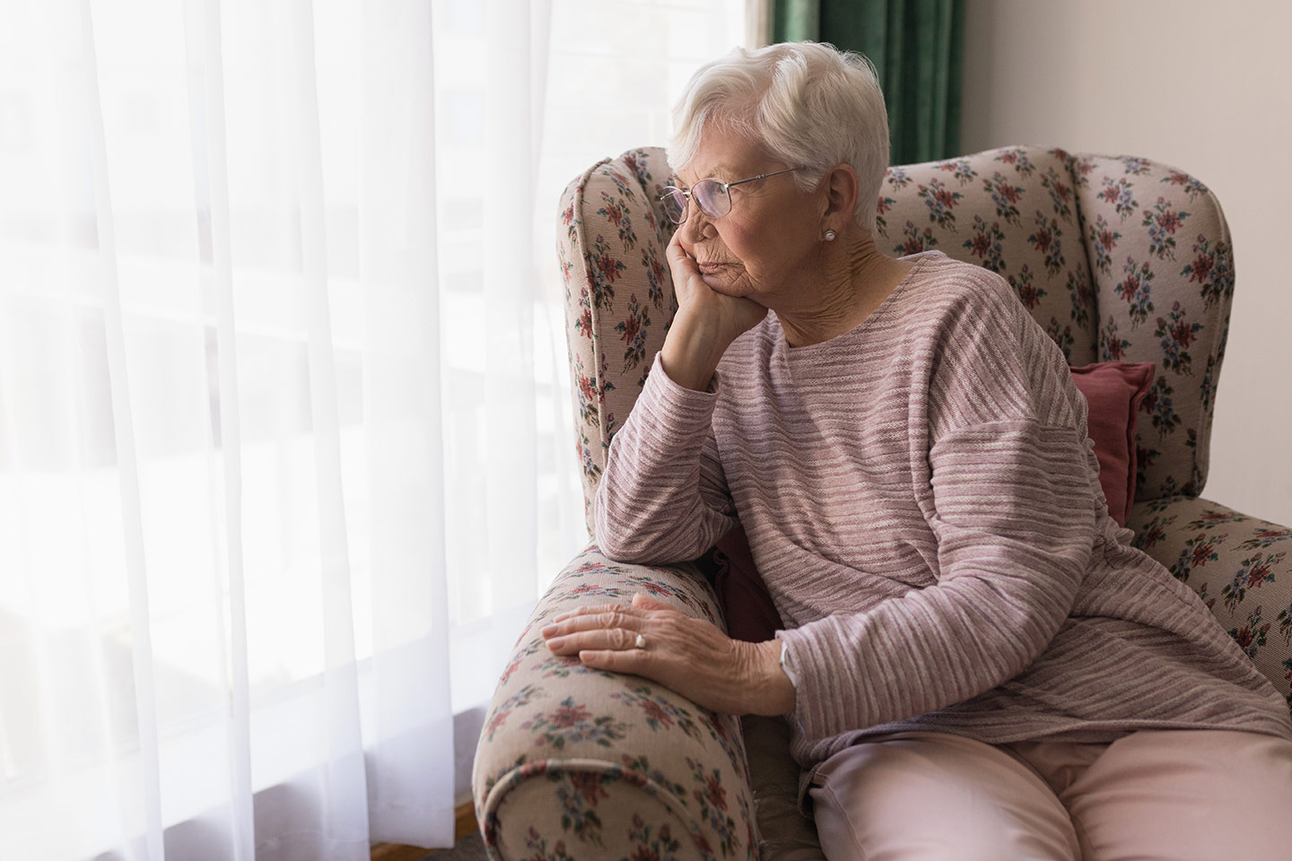 Photo of a woman seated in a floral armchair
