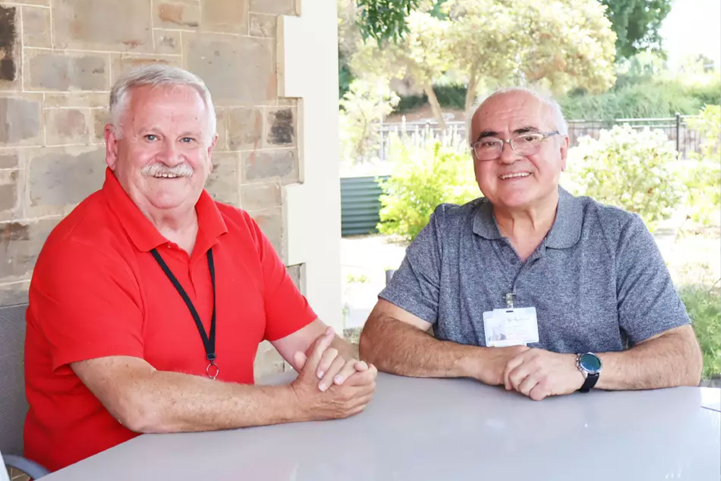 Photo of two smiling men sitting at a table